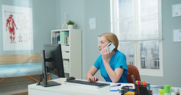 Krásná Sestřička Pracující Počítači Zatímco Telefonuje Nemocniční Kanceláři Mladá Běloška — Stock video