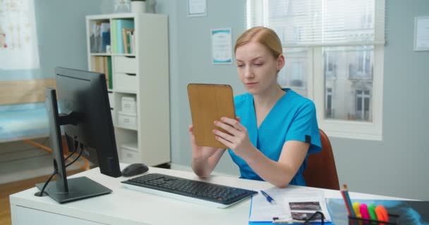 Důvěryhodná Mladá Sestřička Pracující Gadgetem Pohotovosti Nemocnici Běloška Lékařské Uniformě — Stock video