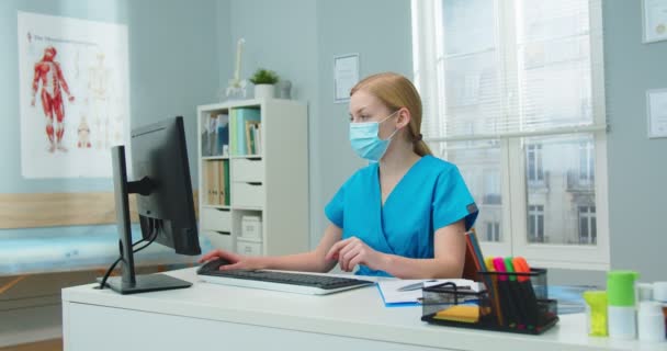 Professionelle Kaukasische Klinikangestellte Schutzmaske Die Computer Arbeitet Eine Junge Krankenschwester — Stockvideo