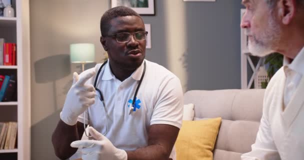Blisko Afroamerykanin Poważny Młody Lekarz Specjalista Medyczny Siedzi Kanapie Rozmawiając — Wideo stockowe