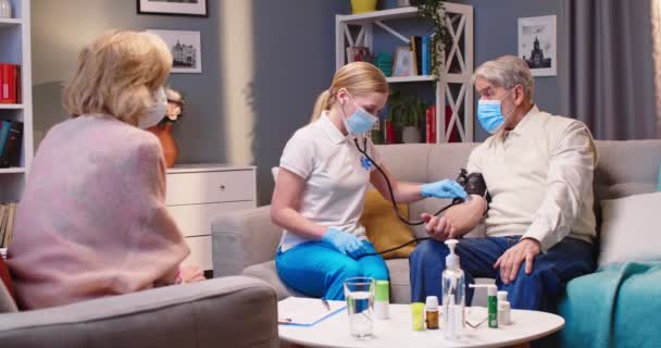 Молодая Белая Женщина Врач Медицинской Маске Проверяет Здоровье Измеряя Артериальное — стоковое видео