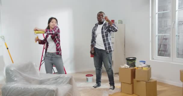 Молода Багатоетнічна Позитивна Щаслива Пара Чоловік Дружина Танцюють Кімнаті Під — стокове відео