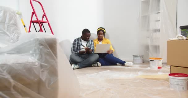 즐거운 아내와 아프리카계 미국인 리노베이션 과정에서 새로운 색상을 선택하고 노트북에 — 비디오