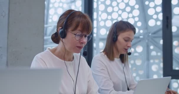 Orta Yaşlı Kulaklıklı Genç Beyaz Kadınlar Ofisteki Dizüstü Bilgisayarların Çağrı — Stok video