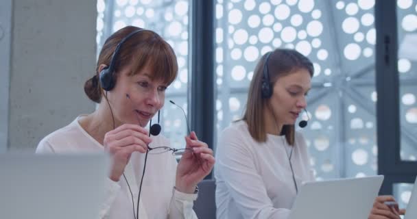 Kulaklık Takmış Orta Yaşlı Beyaz Bir Kadın Ofisteki Dizüstü Bilgisayarların — Stok video