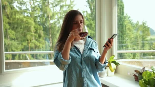 아름다운 코카서스 여성은 커피를 마시고 집에서 전화로 입력합니다 진정성 균형과 — 비디오