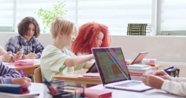 İlgili okul öğrencileri ders sırasında dijital tabletler üzerine ders veriyorlar. Kablosuz bilgisayarı olan bir öğretmen zeki çocuklarla dolu sınıfa materyalleri açıklıyor..