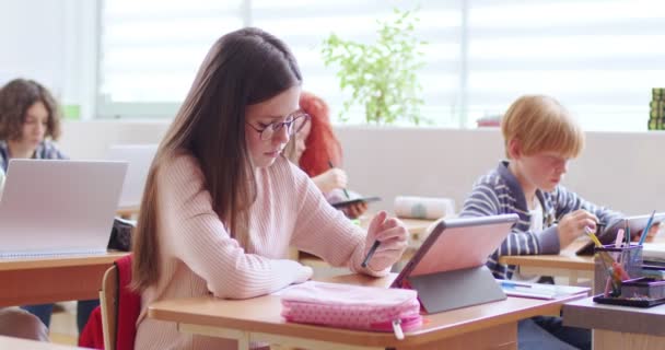 Kaukasische Schülerin Mit Brille Sitzt Schreibtisch Klassenzimmer Schreibt Und Benutzt — Stockvideo