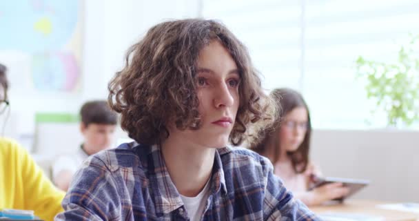 Kafkasyalı Uzun Saçlı Bir Gencin Sınıfta Otururken Kameraya Bakışının Portresi — Stok video