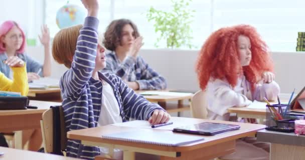 Estudantes Sorridentes Sentados Mesa Sala Aula Moderna Levantando Mãos Durante — Vídeo de Stock
