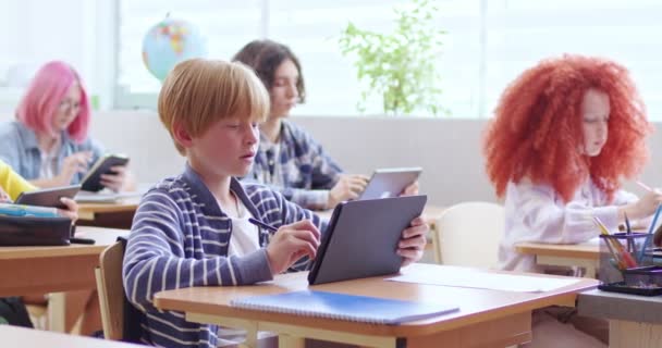 Small Caucasian Schoolboy Sitting Desk Classroom Kids Lesson Using Tablet — Stock Video