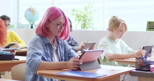 Έφηβος Καυκάσιος Μαθητής Κορίτσι Γυαλιά Ροζ Μαλλιά Κάθεται Στο Γραφείο — Αρχείο Βίντεο