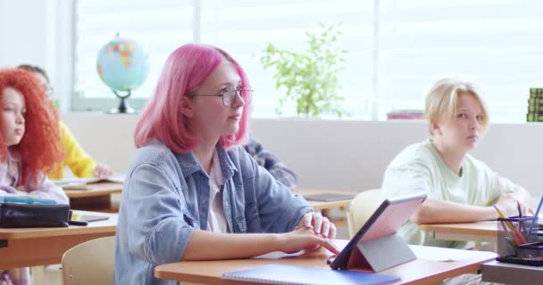 Šťastná Dospívající Běloška Brýlích Růžovými Vlasy Sedí Stolem Tabletovým Zařízením — Stock video