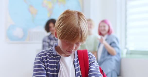 Sorgsen Mobbad Pojke Stående Klassrummet Medan Tre Klasskamrater Bakom Honom — Stockvideo