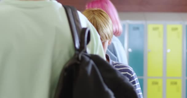 图片中可爱的白人小男孩站在学校走廊中间休息 使用智能手机和摄像头 一个带着小玩意的小学生 上学的生活方式 — 图库视频影像