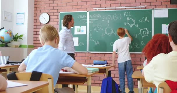Back View Caucasian Schoolboy Writing Chemical Formulas Blackboard While Answering — Stock Video