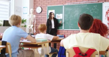 Siyah takım elbiseli, gözlüklü, DNA ve RNA özellikleri olan çekici bir kadın sınıfta biyoloji dersi sırasında tahtaya yazılmış. İlginç öğrenim için modern eğitim sistemi.