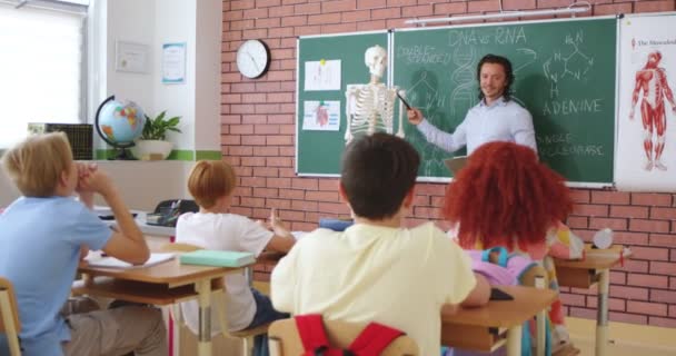 Yakışıklı Beyaz Erkek Anatomi Biyoloji Öğretmeni Öğrencilere Insan Vücudunu Kemiklerini — Stok video