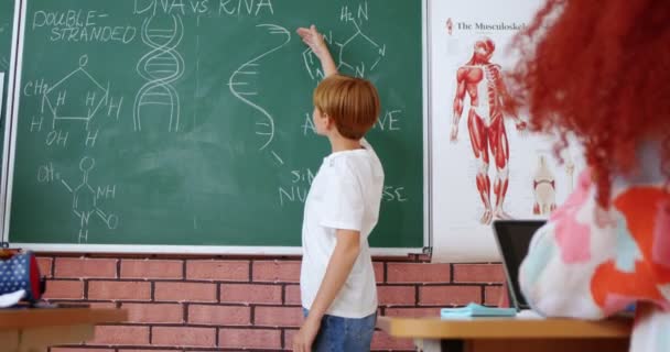 Кавказский Мальчик Подросток Отвечает Доску Перед Учительницей Биологии Пишет Решает — стоковое видео