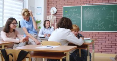 İlkokul öğrencileri günlük kıyafetleriyle sohbet ediyorlar ve okul tatilinde modern aletler kullanıyorlar. Eğitim ve rahatlama teknolojisi.