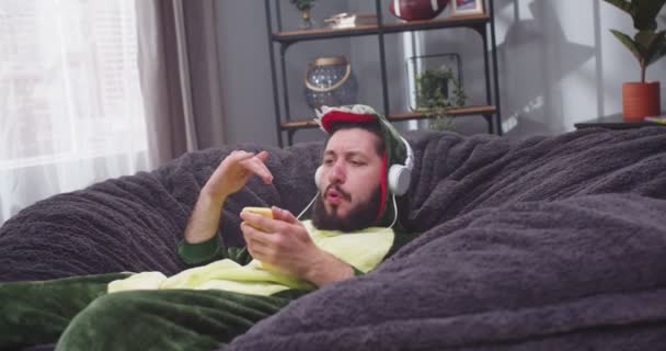 Tutup Potret Pria Dewasa Sofa Dengan Smartphone Tangannya Mendengarkan Musik — Stok Video