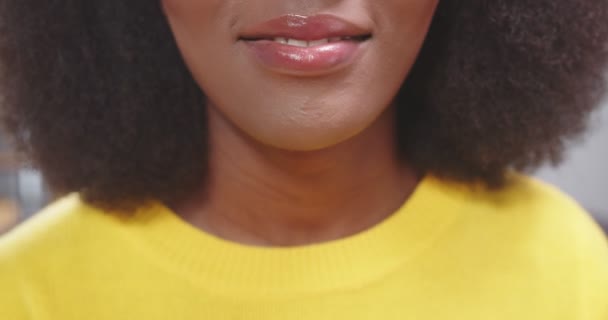 非洲裔美国妇女的近照 女孩笑着带着牙齿 穿着黄色毛衣的女人快乐的人的概念 慢动作视频 — 图库视频影像