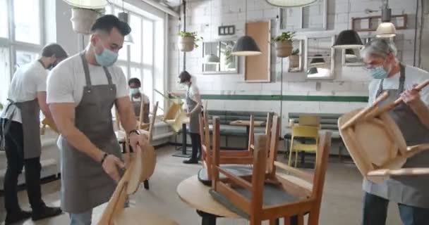 Mixed Races People Aprons Masks Cleaning Cafe Taking Out Chairs — Stock Video