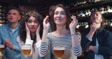 Bir grup genç arkadaş barda birlikte televizyon izleyip, bira içerken spor takımını destekliyorlar. Erkekler ve kızlar gerginlikte el kaldırır, bağırır ve hayal kırıklığıyla yüzlerini kapatırlar..