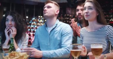Bir grup arkadaş barda takılır, televizyon izler ve bira içerken spor takımını desteklerler. Gençler tezahürat yapıyor, bağırıyor, sarılıyor ve alkışlarken, bir erkek hayal kırıklığı içinde içiyor..