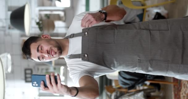 Young Caucasian Man Apron Holds Smartphone Talks Phone Camera Smiling — Stock Video