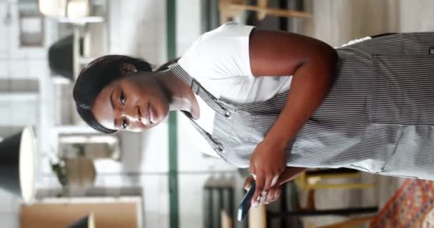 Joven Mujer Afroamericana Delantal Mira Lejos Del Teléfono Para Sonreír — Vídeo de stock