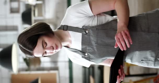 站在咖啡厅的漂亮的白种人年轻女服务员的垂直肖像 使用数码设备 微笑着看着相机 餐厅女厨师用平板电脑发短信 — 图库视频影像