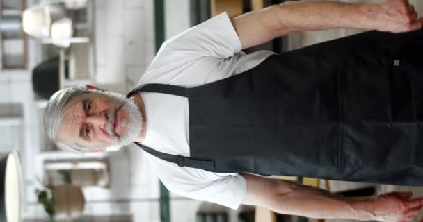 Bearded Grey Haired Man Apron Talks Camera Gesturing Hands Giving — Stock Video