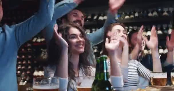 금요일 술집에서 시간을 보내고 치어리더 움직임을하는 코카서스 남성과 여성의 치어리더들 — 비디오