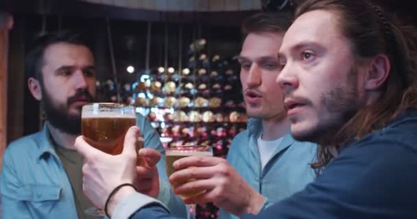 Grupa Młodych Mężczyzn Przesiaduje Barze Stuka Szklankami Pije Piwo Omawia — Wideo stockowe