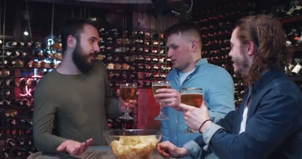 一群年轻人在酒吧里混在一起 喝啤酒吃一碗小吃 三个朋友聊得很愉快 面带微笑打盹 — 图库视频影像
