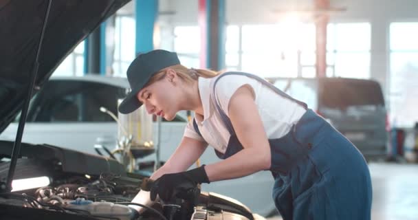 白种人女机修工身穿制服 护目镜修理汽车发动机 年轻的女工程师在大车库里修理汽车引擎 维护概念 修理工作 — 图库视频影像