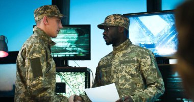 Beyaz ve Afro-Amerikan asker üniformalı askerler askeri ofiste buluşup el sıkışarak selamlaşıyorlar. Ordudaki erkek çoklu etnik gruplar bazı operasyon konularını konuşuyor ve tartışıyorlar..