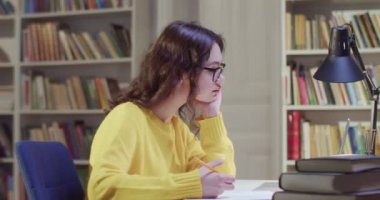 Beyaz tenli, gözlüklü, kütüphanede ders çalışan ve notlar yazan güzel bir kadın. Kitap okurken önemli bilgilerle notlar alan kadın öğrenci.