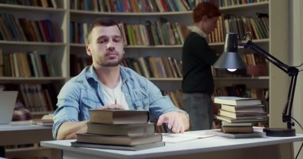 Кавказский Юноша Работает Старыми Книгами Библиотеке Делает Заметки Студент Мужчина — стоковое видео
