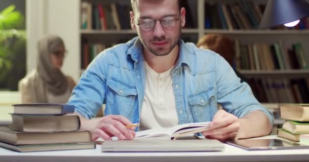 Kütüphanede Kitap Okuyan Sonra Kameraya Bakan Gözlüklü Yakışıklı Beyaz Adamın — Stok video