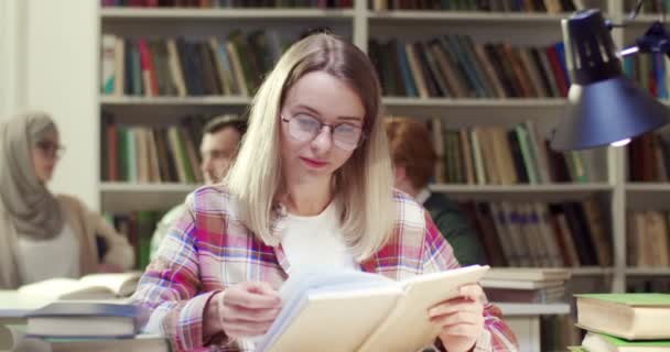 Retrato Filmado Jovem Loira Alegre Estudante Caucasiana Óculos Leitura Livro — Vídeo de Stock