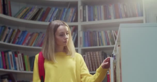 Blondynka Młoda Piękna Studentka Rasy Kaukaskiej Czerwonym Plecakiem Spacerująca Bibliotece — Wideo stockowe