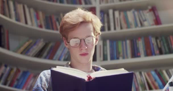 Close Branco Ruivo Jovem Estudante Sexo Masculino Óculos Livro Leitura — Vídeo de Stock