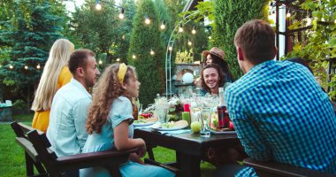 Birçok melez genç insan masada oturup bahçede konuşuyor. Afro-Amerikalı ve beyaz güzel kızlar dışarıda gülümsüyor. Neşeli Asyalı kız ve yakışıklı erkekler sohbet ediyorlar. Kutlama konsepti