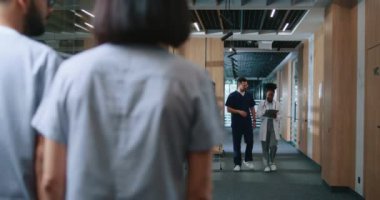 Yetenekli beyaz fizyoterapist ve yardımcı hemşire koltuk değnekli adamı destekleyip yardım ediyor. Hastalar ve çalışanlar hastane koridorlarında ilerliyorlar. Modern tedavi kavramı.