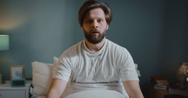 Güzel beyaz adam bir kabustan uyanıyor. Genç erkek sakin ol ve uyumaya devam et..