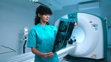 Hastane araştırma merkezindeki doktor nörolog, MRI taramasının sonuçlarına göre hasta için daha iyi bir tedavi yöntemi belirledi. Nitelikli nörolog CT taramasını inceliyor..
