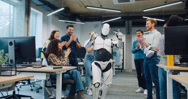 Kameralar beyaz, modern biyonik insana odaklanırken yakınlaşıyor. Robotu çevreleyen ve elleriyle alkışlayan yaratıcılar. Otomatik cihaz hareket ediyor. Kişiye benzemeye çalışıyorum..