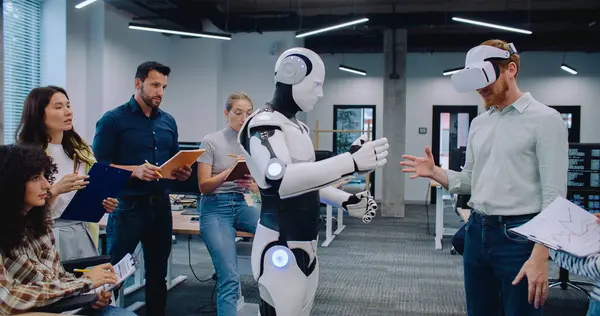 Birbirlerine yakın duran ve ofis binasındaki test sonuçlarını not eden çok ırklı bir grup mühendis. VR kulaklıklı bir adam insansı robotu çalıştırmaya çalışıyor. Cyborg erkekten sonra tekrarlıyor.